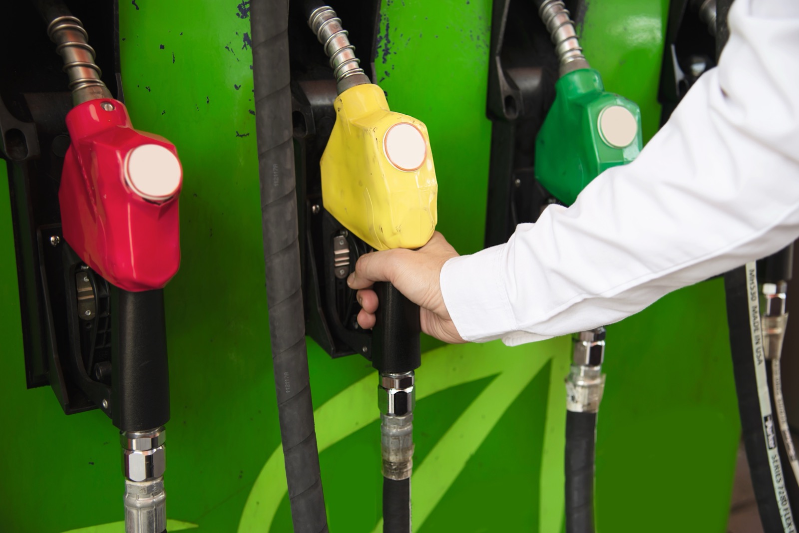 Driver refuelling a car at a petrol station pump